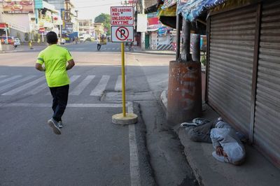 Rear view of man with umbrella on street