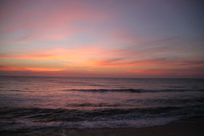 Scenic view of sea against cloudy sky at sunset