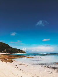 Scenic view of beach against blue sky