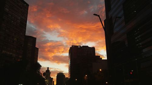 Buildings in city against sky at sunset