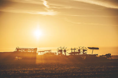 Silhouette field against sky during sunset