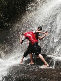 Full length of man jumping on water