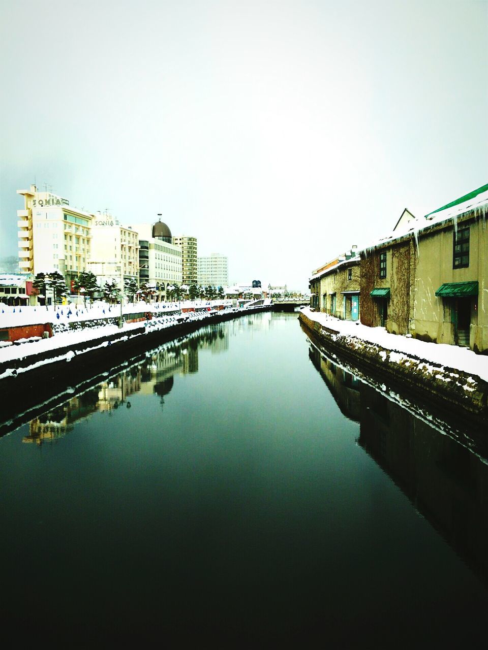 architecture, built structure, building exterior, clear sky, water, reflection, waterfront, copy space, canal, city, river, building, residential structure, residential building, day, connection, outdoors, bridge - man made structure, sky, travel destinations