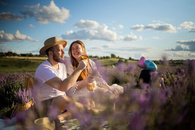Couple drinking wine on picnic on lavender field