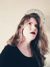 Close-up portrait of young woman against white background