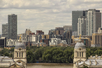 View of cityscape against cloudy sky