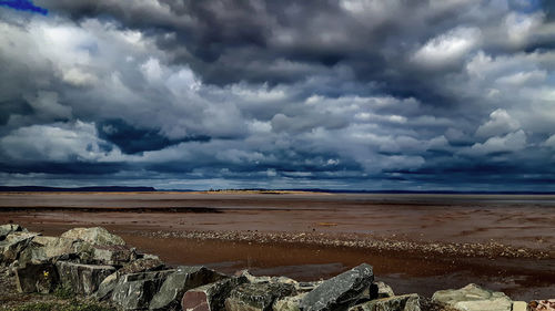Scenic view of beach against storm clouds