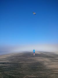 Person paragliding against clear sky