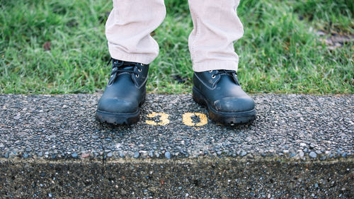 Low section of person standing on stone railing