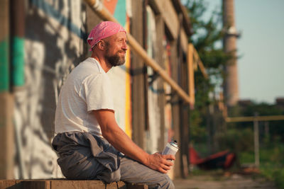 Side view of man using mobile phone outdoors