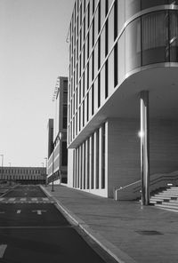 Empty footpath by building against sky