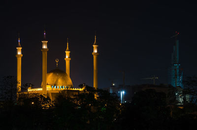 Illuminatednational mosque of abuja against sky during night