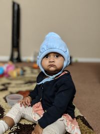 Portrait of cute baby girl sitting at home