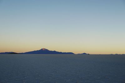 Scenic view of salar de uyuni against sky during sunrise