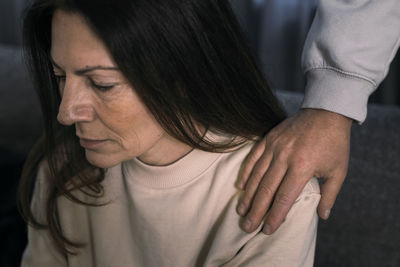 Man putting hand on arm of depressed woman