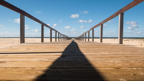 Pier at beach against sky