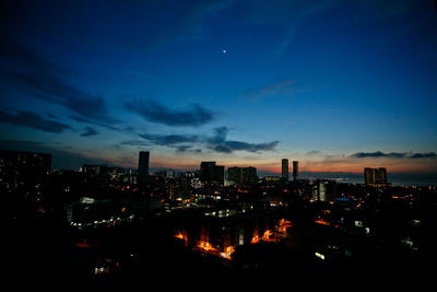 High angle view of illuminated buildings against sky at dusk