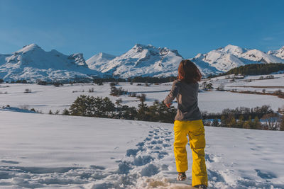 An unrecognizable young caucasian woman running towards the french alps mountains