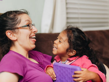 Mother and mixed race daughter at home having fun using a learning tablet computer 