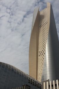 Low angle view of modern building against cloudy sky