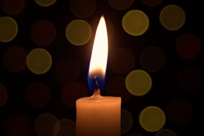 Close-up of burning candle in darkroom