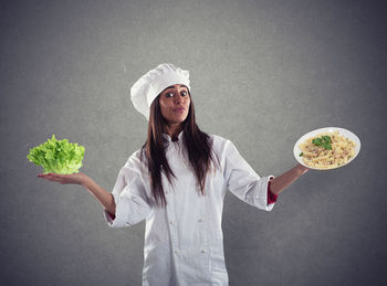 Young woman holding food against white background