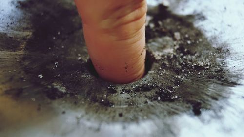 Close-up of person hand on wet table