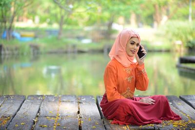 Side view of young woman sitting outdoors
