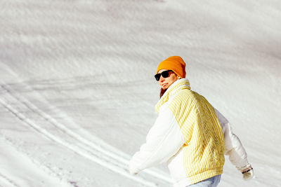 Portrait of woman standing on snow covered landscape