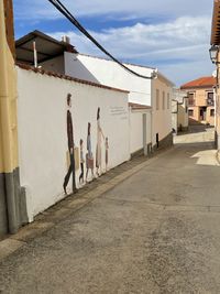 Rear view of people walking on street against buildings