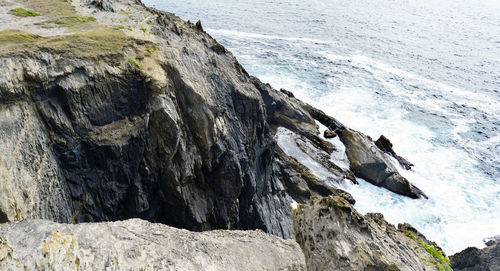 Rock formations by sea against sky