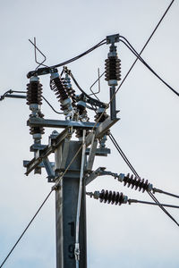 Low angle view of electricity pylon against sky