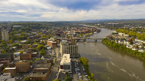 High angle view of river amidst buildings in city against sky