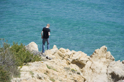 Rear view of man standing on coast