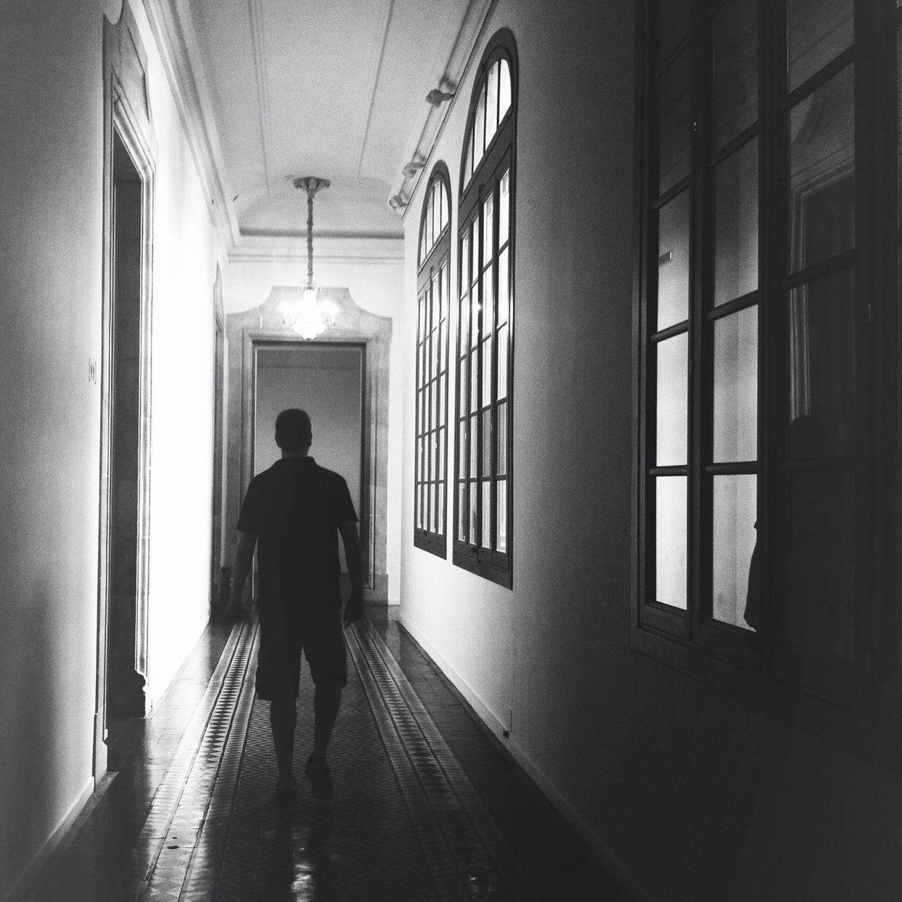 indoors, architecture, built structure, silhouette, full length, rear view, men, walking, lifestyles, standing, window, corridor, building, person, unrecognizable person, the way forward, reflection, arch