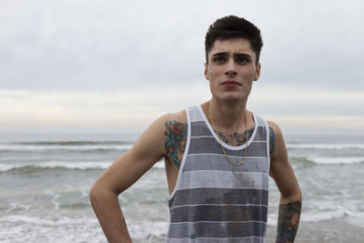 Portrait of young man standing on beach