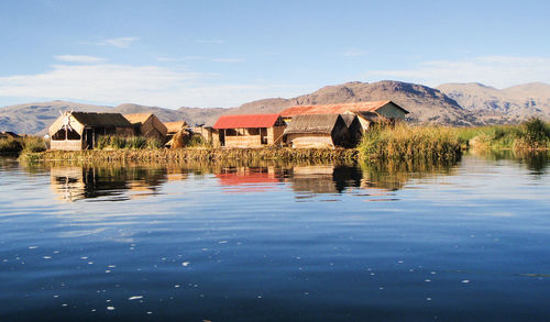 Houses on shore against blue sky