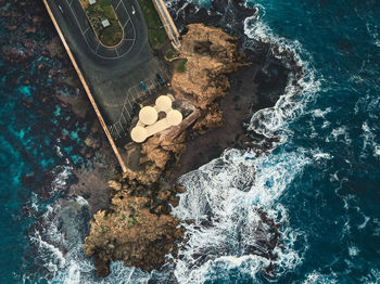 High angle view of rocks on sea shore