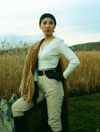 Portrait of young woman standing on field