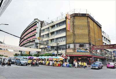 People on street against buildings in city