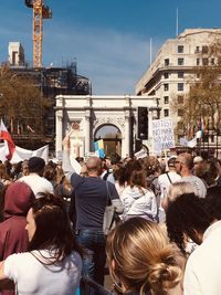 People on street in city against sky