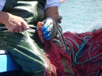 Midsection of fisherman holding fishing net