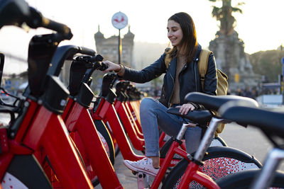 Woman climbing on a red electric bike.