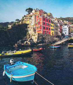 Boats moored on sea by buildings in city