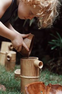 Young boy playing with water and wood