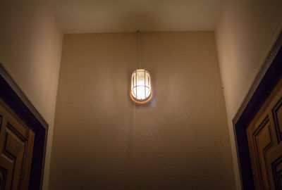 Low angle view of illuminated pendant light hanging from ceiling in building