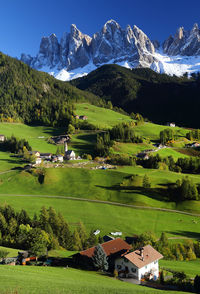 Scenic view of agricultural field and houses against sky