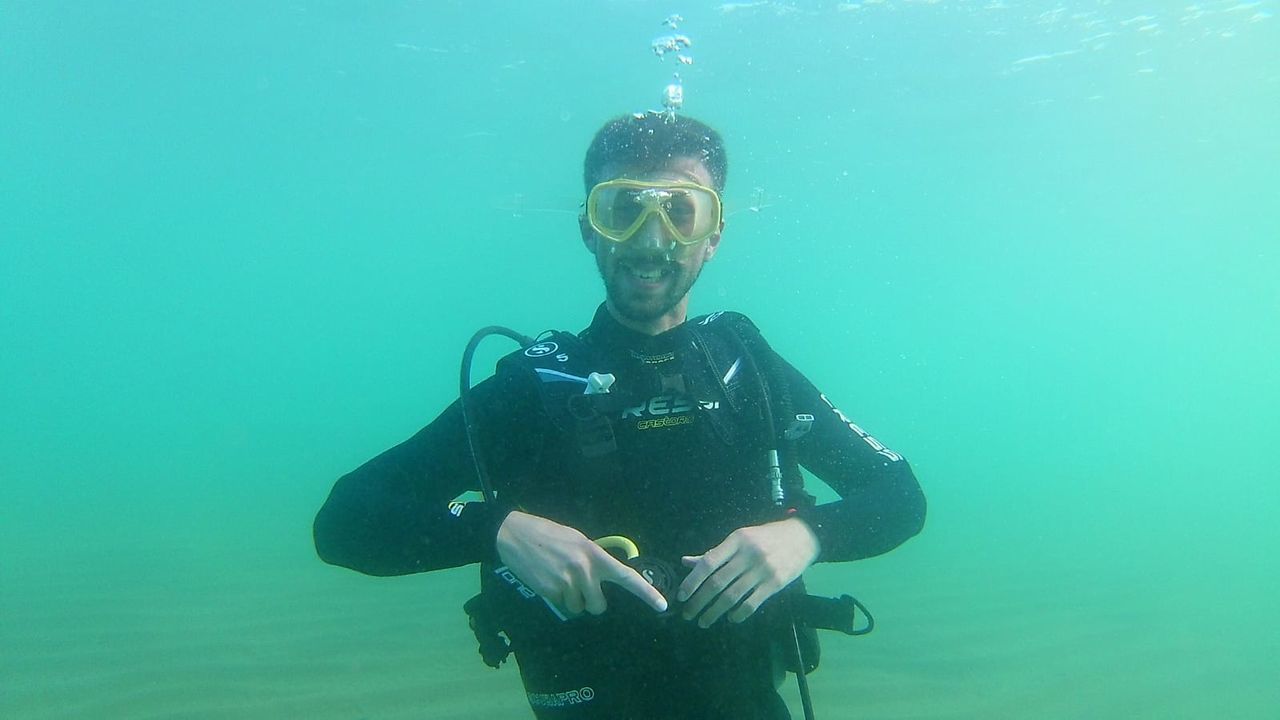 FULL LENGTH OF MAN SWIMMING UNDERWATER