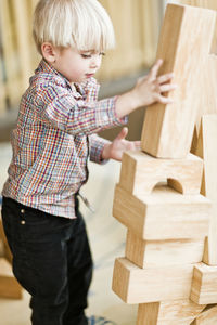 Boy building tower with wooden blocks