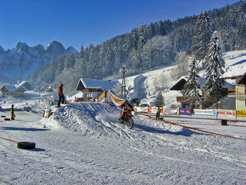 People skiing on snowcapped mountain against sky